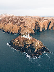 aerial photography of lighthouse on hill thumbnail