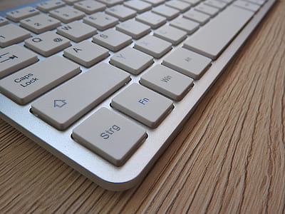 White Computer Keyboard on Brown Wooden Table thumbnail
