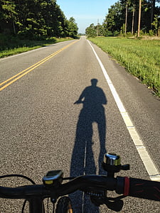 person biking on road beside tree thumbnail