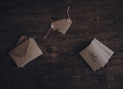 envelopes and two product tags on brown surface thumbnail