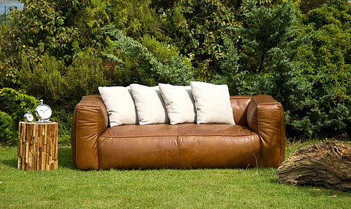 brown leather couch with four white throw pillows on top thumbnail