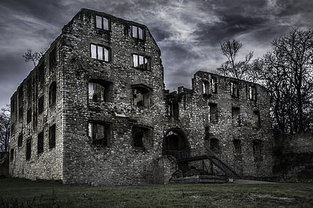 grey concrete building beside bare trees under grey clouds thumbnail