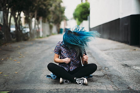 man wearing black denim jeans sitting beside the buildign thumbnail
