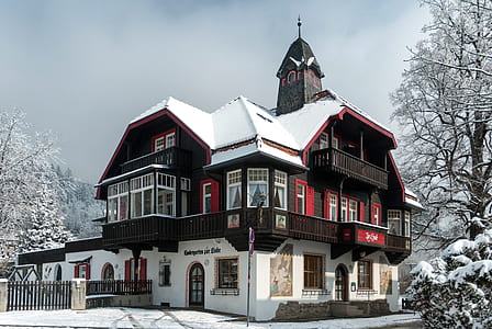 red and black wooden house covered by snow thumbnail