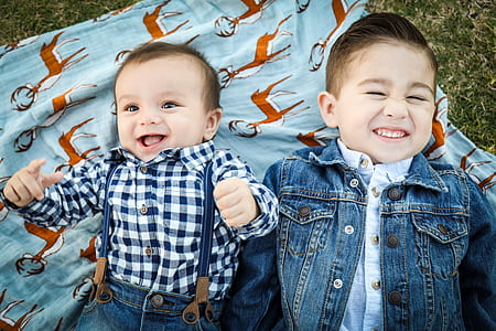 baby boy and toddler boy lying next to each other thumbnail