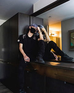man wearing face mask sitting on dresser thumbnail