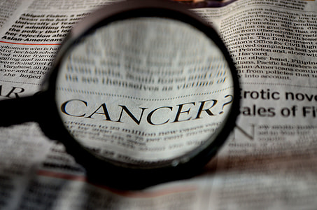 newspaper article with magnifying glass viewing the word of cancer thumbnail