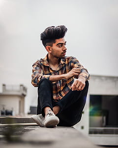 man sitting on gray building thumbnail