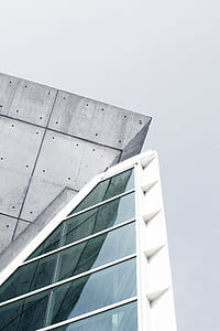 low-angled photography of white and grey concrete building with clear glass windows thumbnail