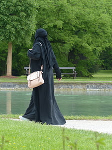 woman wearing black niqab walking on sidewalk thumbnail