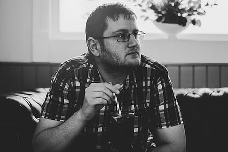 Grayscale Photo of Man Sitting on Sofa thumbnail