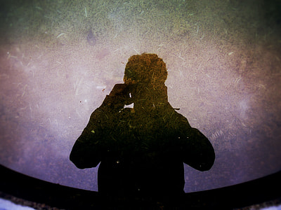 silhouette of a man taking a picture in front of the mirror thumbnail