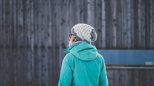 person wearing teal hooded jacket and white knit cap thumbnail