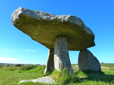 gray rock formation on green grass field under clear blue sky thumbnail