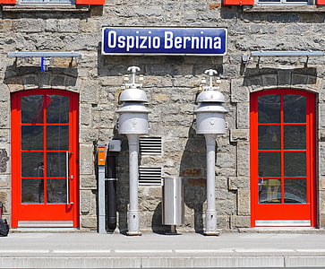 two white metal post between two red doors thumbnail