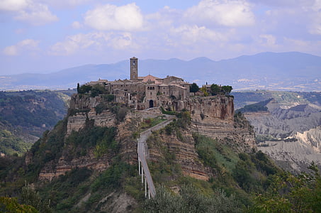 high angle photo of castle surrounded by mountain range thumbnail