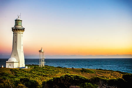 white lighthouse near seashore thumbnail