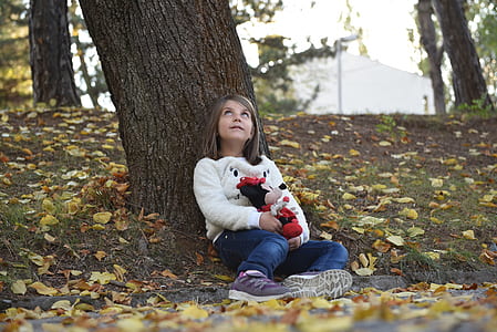 girl sitting lean on tree with mickey mouse plush toy thumbnail