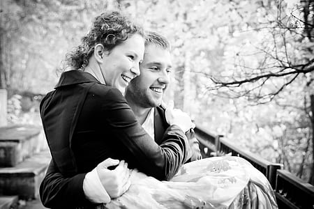 grayscale photography of man carrying woman while smiling thumbnail