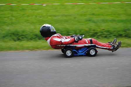 person riding blue ride-on toy on track thumbnail