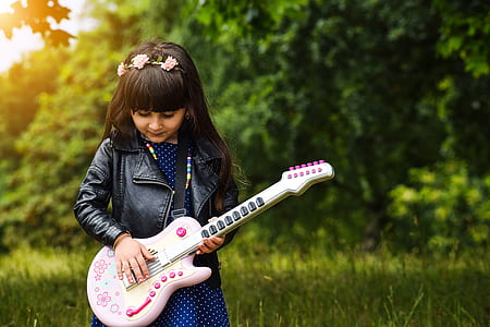shallow focus photography of girl holding guitar thumbnail