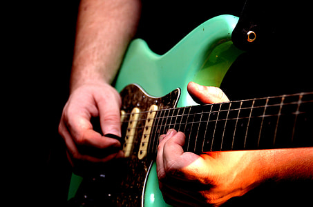 person holding green stratocaster electric guitar thumbnail