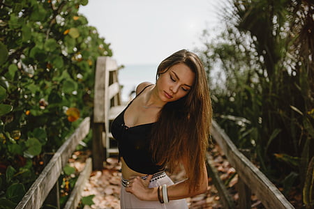 woman wearing black spaghetti crop-top standing on bridge at daytime thumbnail