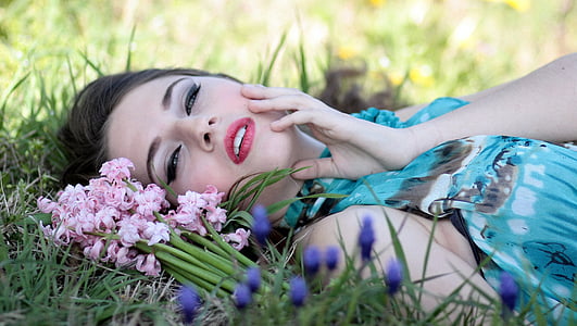 woman laying on grass field with flowers thumbnail