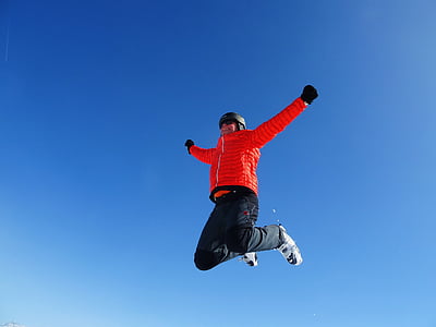 person in red bubble jacket jumping during daytime thumbnail