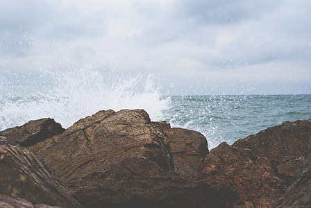 rock formation in front of body of water thumbnail