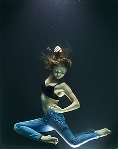 woman in black bra and blue denim jeans sinking in water thumbnail