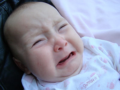 baby crying while laying on pink cloth thumbnail