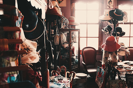 photography of assorted hats and brown wooden curio cabinet inside room during daytime thumbnail