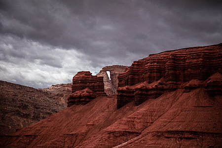 brown rock formation under gray clouds thumbnail