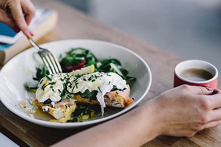 Close up image of young woman eating classic breakfast at restaurant thumbnail