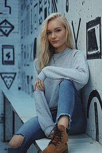woman sitting on white bench leaning on wall thumbnail