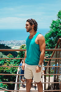 person in blue tank top standing near railings thumbnail