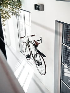 gray and black bike hang on white concrete wall thumbnail