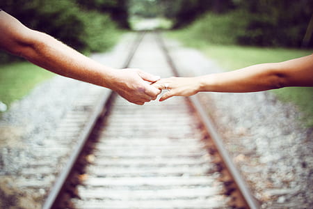 selective focus photography of two person holding hands thumbnail