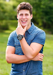 man smiling wearing denim button-up shirt thumbnail