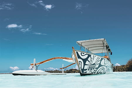 White and Blue Wooden Canoe Under Blue Sky at Daytime thumbnail