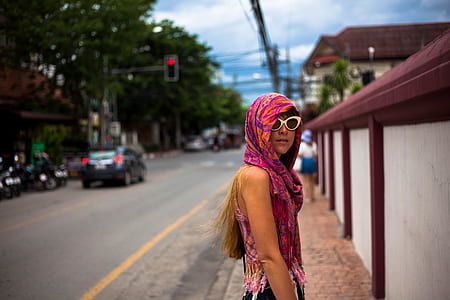 woman standing in between concrete wall and asphalt road thumbnail