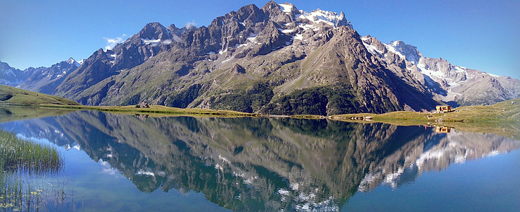 photo of mountain range with reflection on body of water thumbnail