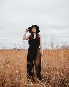 woman in black dress and hat standing on rice field thumbnail
