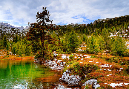 body of water surrounded by trees and rocks thumbnail