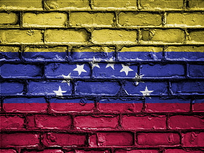 yellow, blue, and red flag with white stars painted on brick wall thumbnail