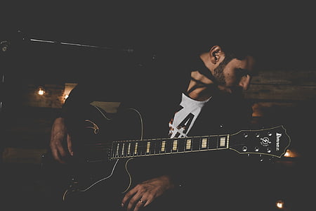 man playing black cutaway acoustic guitar thumbnail