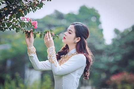 Shallow Focus Photography Of Woman Smelling Flower thumbnail