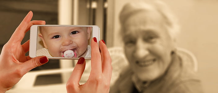person pointing smartphone to woman smiling thumbnail