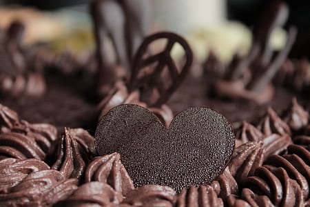 closeup photography of chocolate heart toppings on chocolate icing-covered cake thumbnail